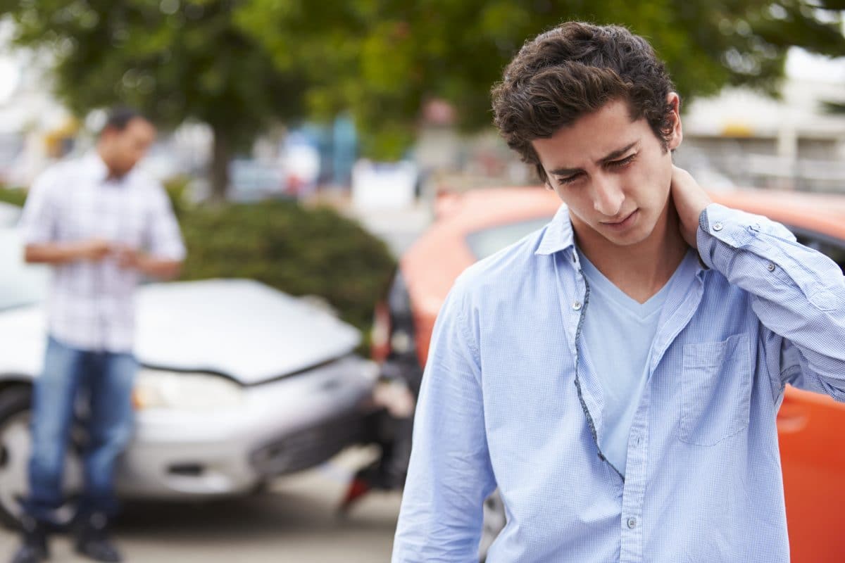 young man experiencing neck pain after car accident