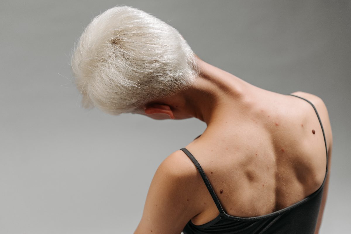 woman stretching neck by tilting head to the side