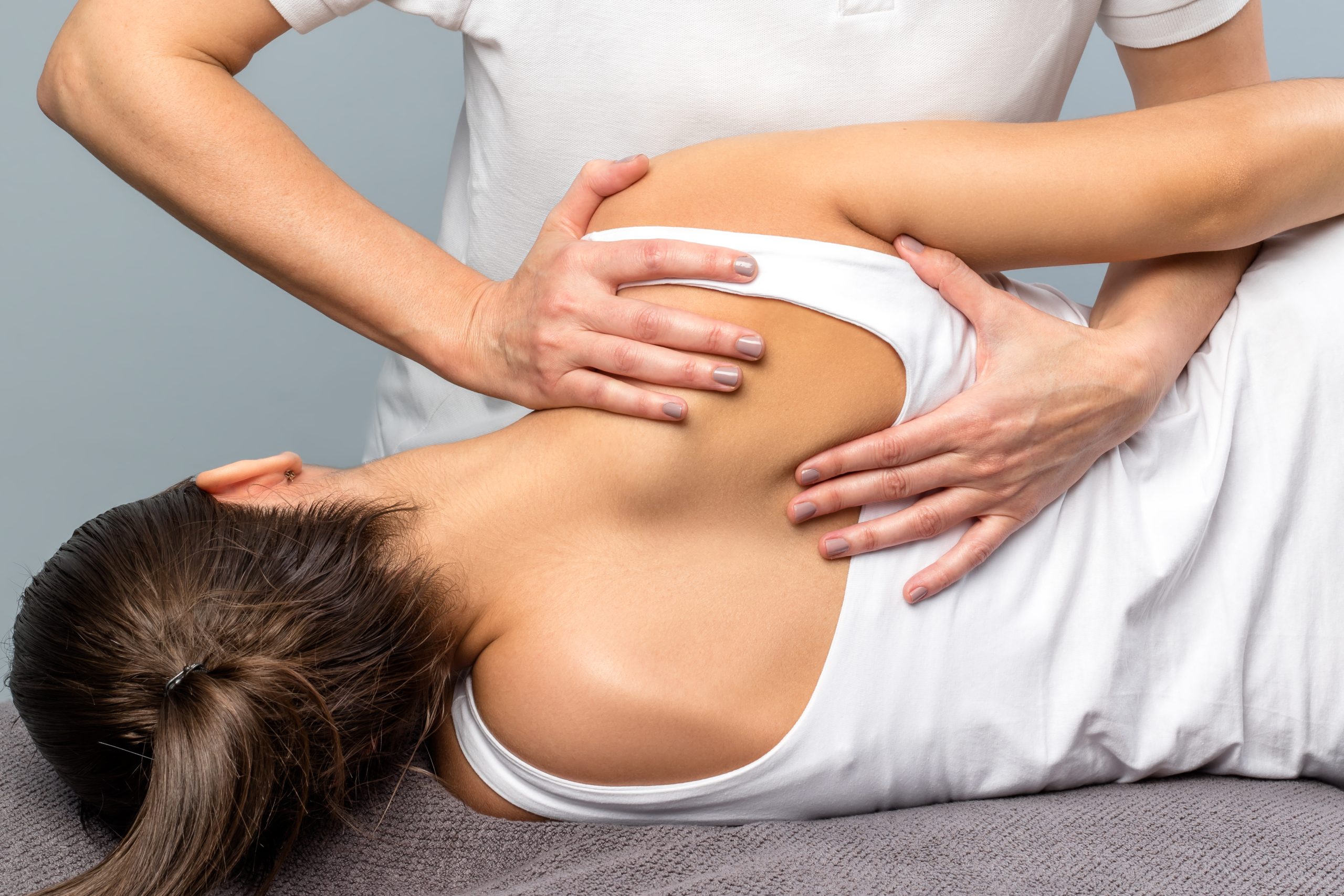 chiropractor adjusting woman's shoulder