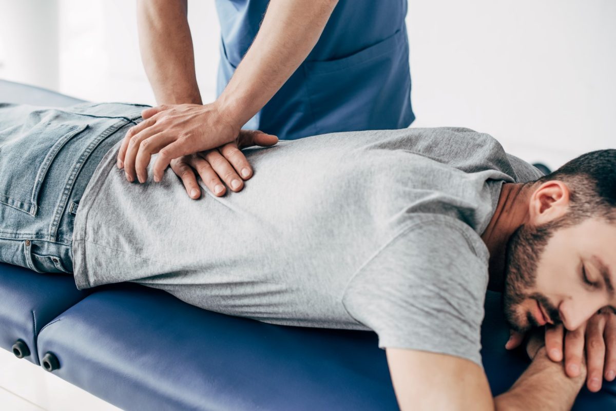 chiropractor adjusting man's lower back