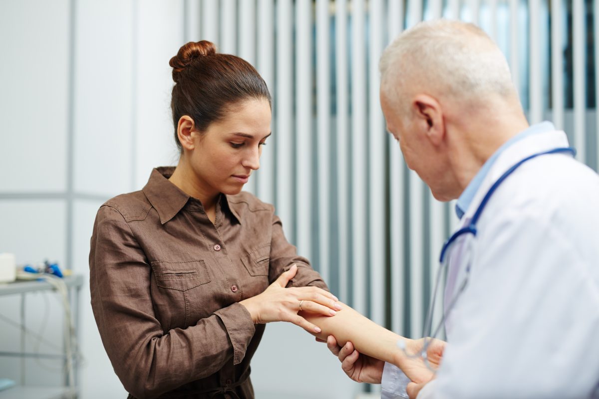 Doctor examining woman's arm
