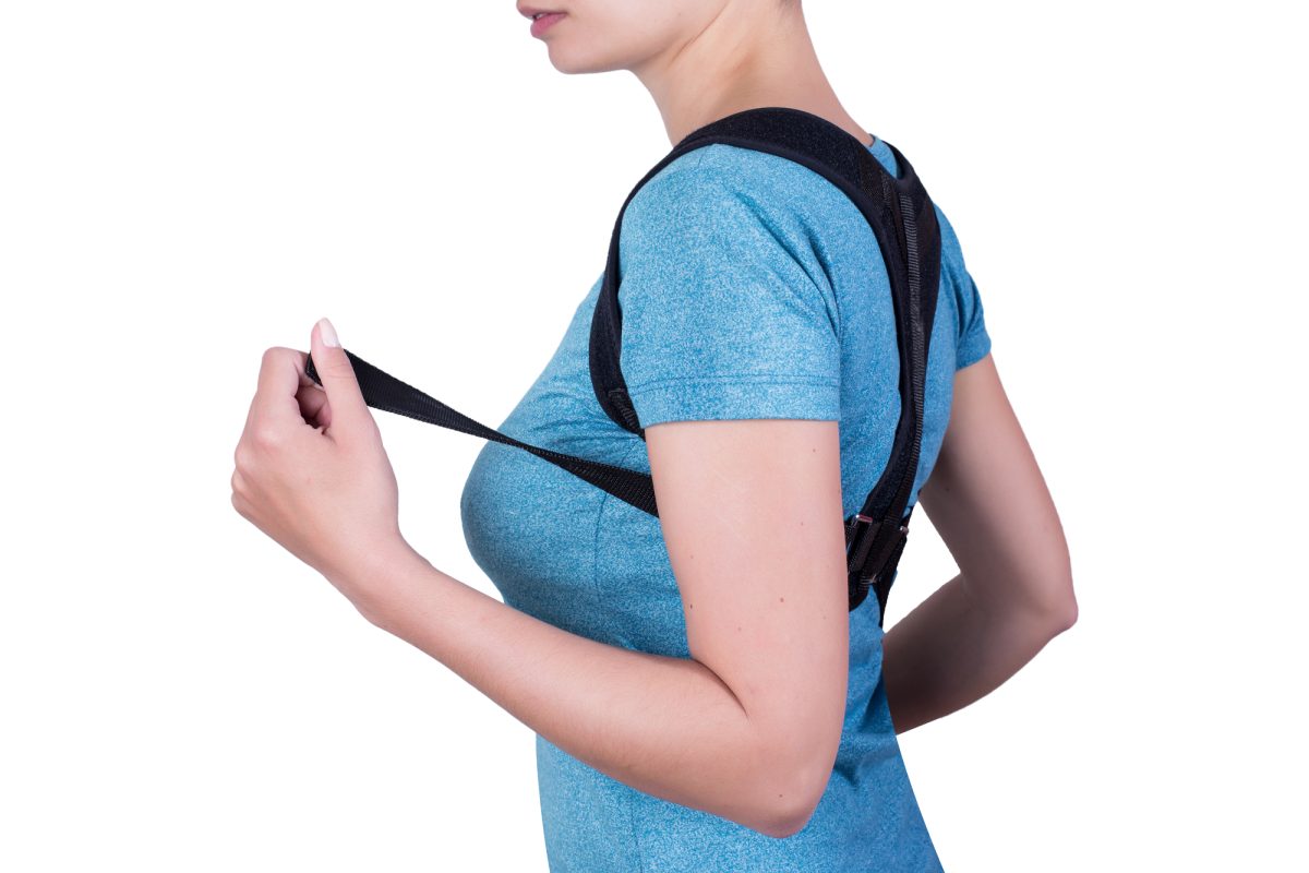 Woman putting on a posture corrector
