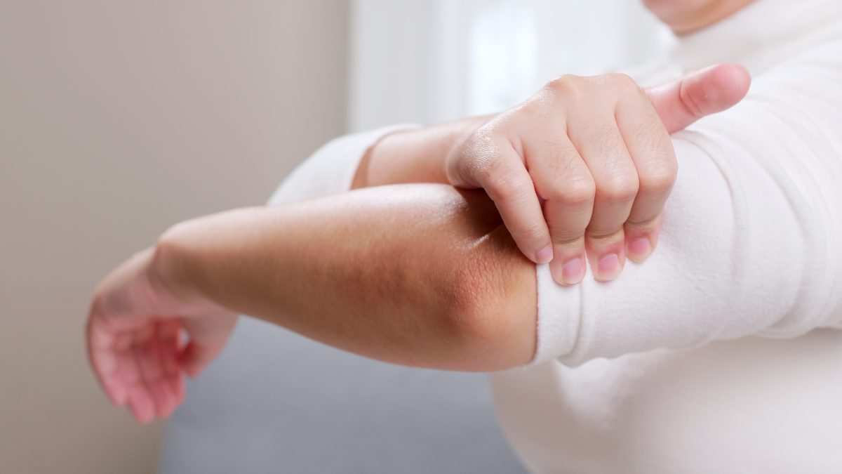 Closeup of woman holding her elbow in pain