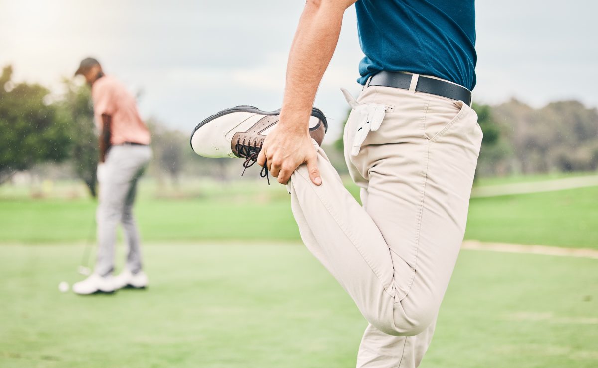 closeup of man stretching legs before a round of golf