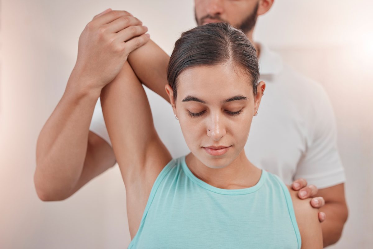 Chiropractor adjusting a patient's shoulder.