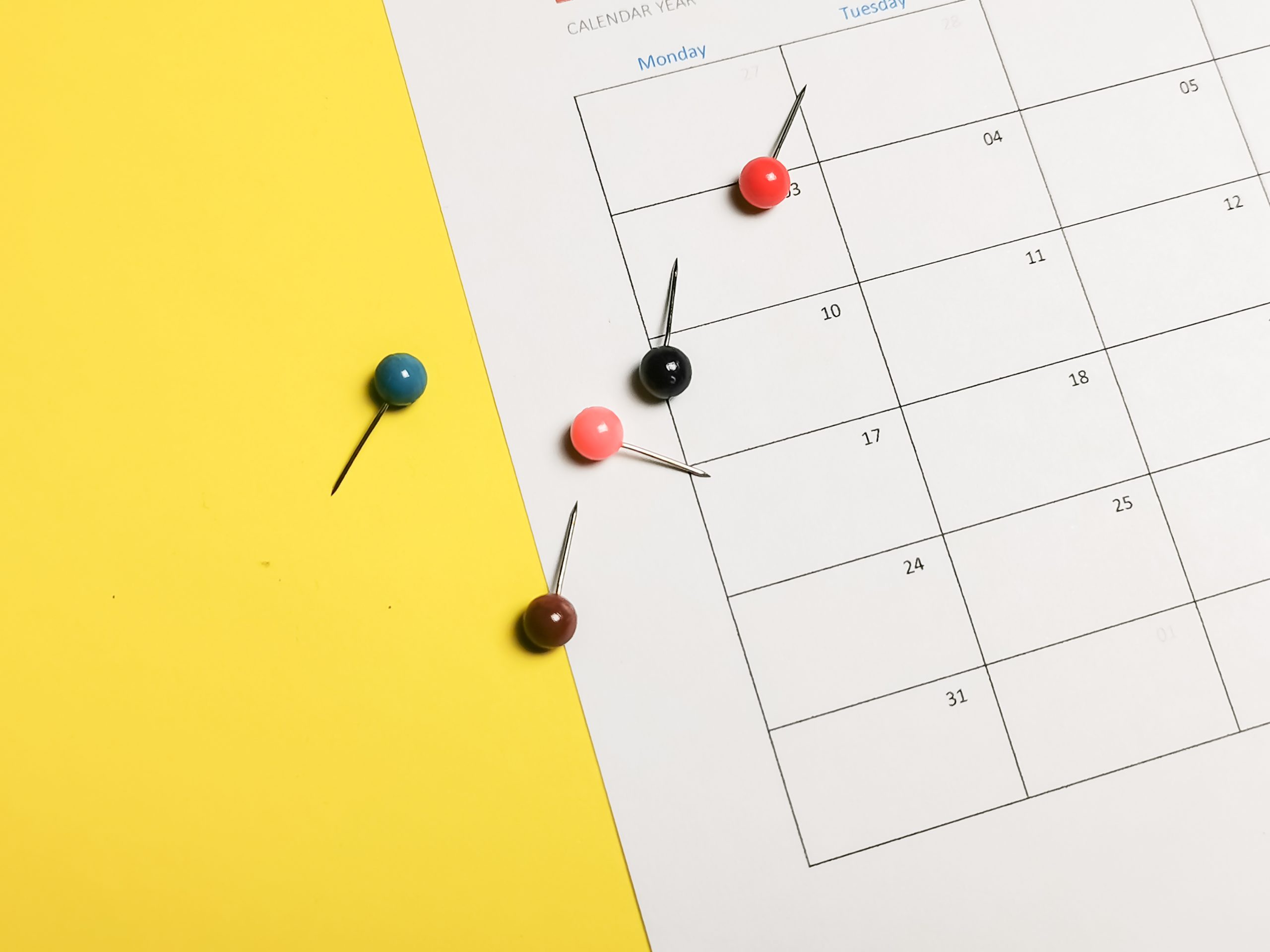 blank calendar page with scattered thumbtacks